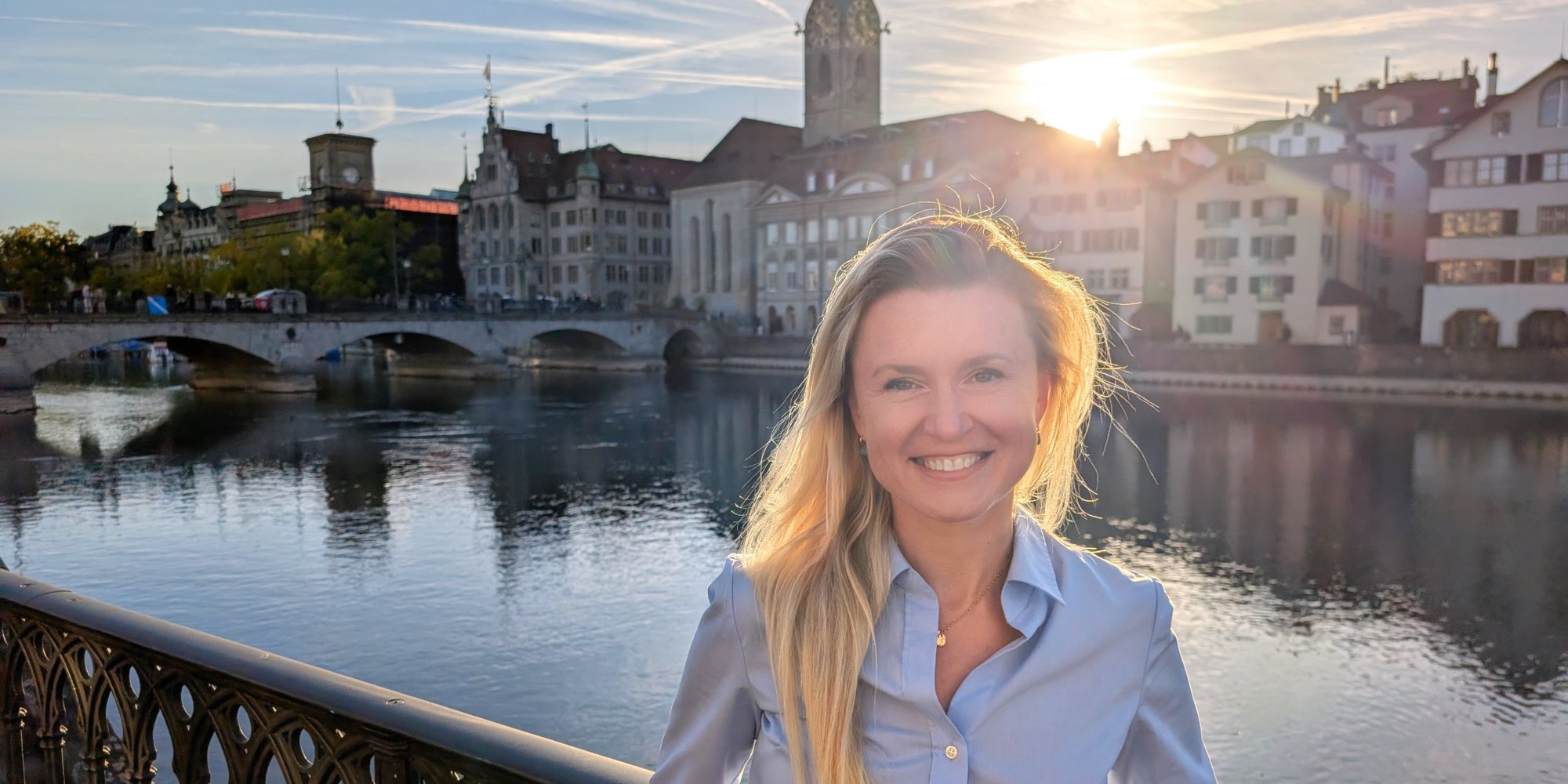 Nataly Taranova, Managing Director of INVIN, standing by the Limmat in Zurich at sunset